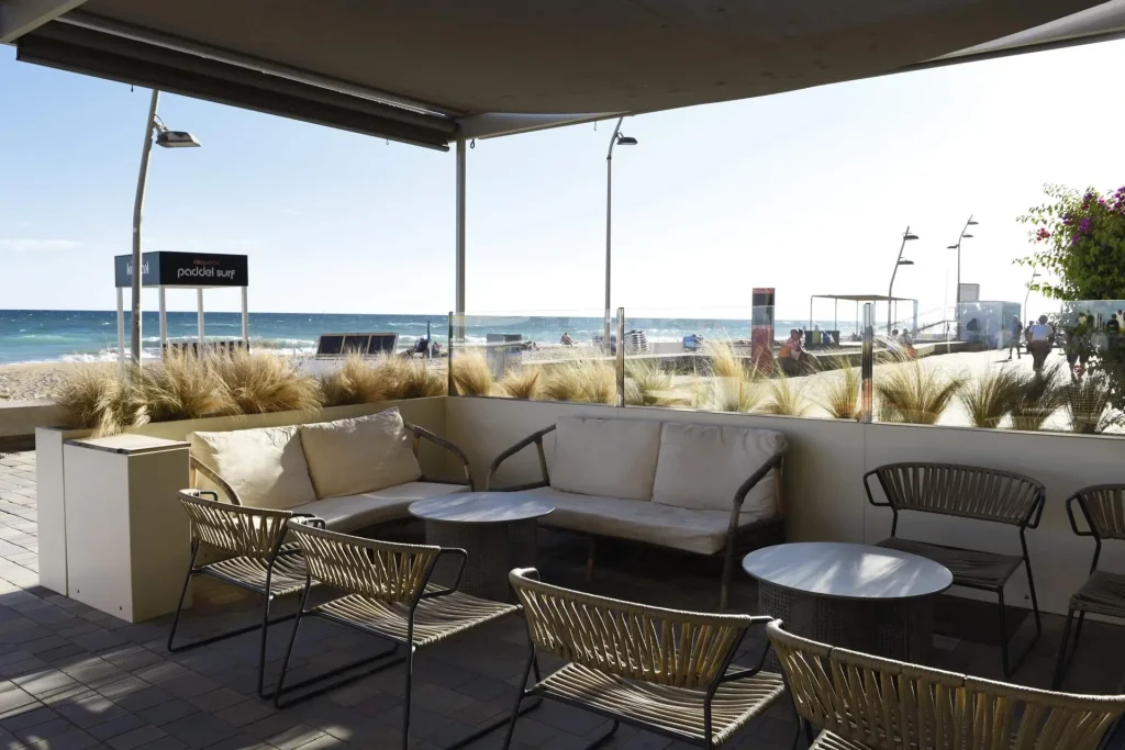 Espace chill-out du Beach Club de l'Hôtel Akquaaa, avec canapés sur la terrasse face à la mer